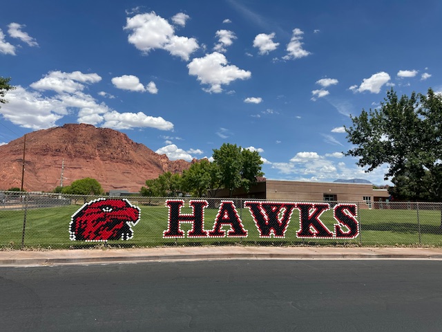 Picture of fence with word Hawks and picture.
